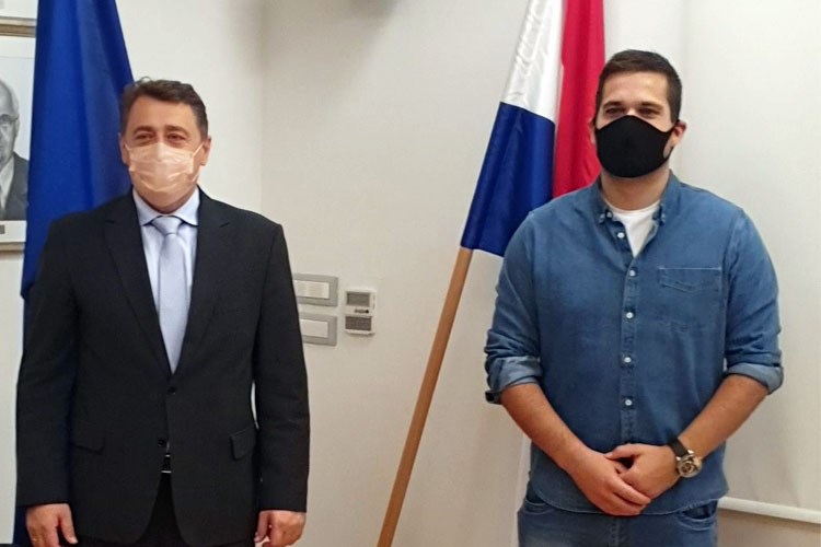 Slika Dr. sc. Damir Šantek stoji uz Dejana Nemcica, obojica s maskama na licu ispred zastava RH i EU.